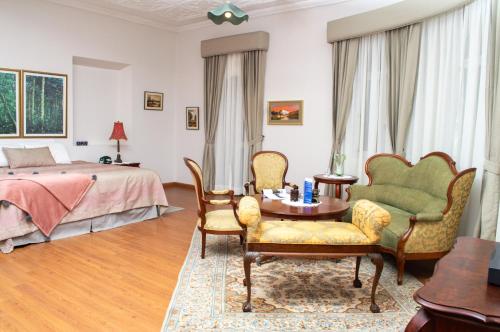 1 dormitorio con 1 cama, mesa y sillas en Hotel La Casona, en Cuenca