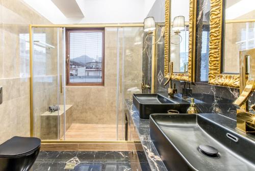 uma casa de banho com 2 lavatórios e um chuveiro em Kallisti Palace em Kissamos
