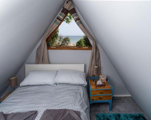 a bedroom with a bed and a window at Chalet Thirteen in Deal