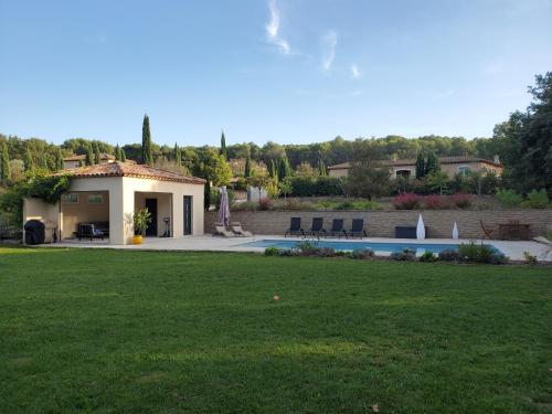une maison avec une pelouse et une piscine dans l'établissement SUPERBE MAISON FAMILIALE AVEC PISCINE, à Cabriès