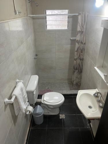 a bathroom with a white toilet and a sink at Magnolia Departamento/Apartment in Barrio Esteban Echeverría
