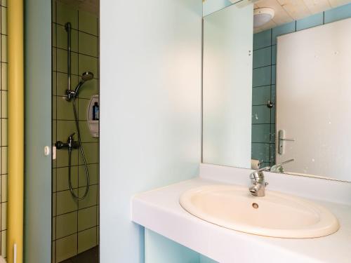 une salle de bain avec un lavabo et un miroir dans l'établissement Vacancéole - Les Monts du Forez, à Saint-Jean-la-Vêtre