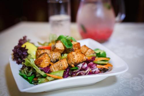 a white plate of food with a salad on a table at Aqua Marina in Karlovy Vary