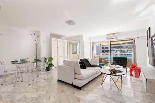 un salon avec un canapé blanc et une table dans l'établissement Le Lucior - FLBK conciergerie, à Cannes