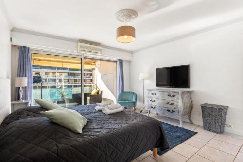 une chambre avec un grand lit et une télévision dans l'établissement Le Lucior - FLBK conciergerie, à Cannes