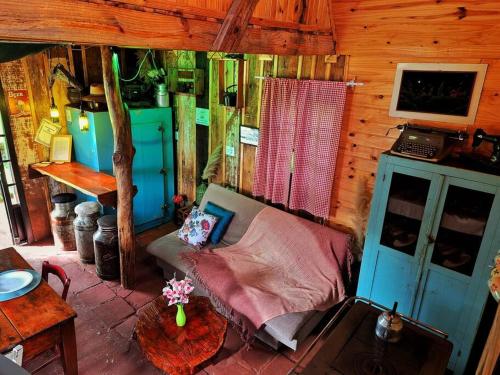 - soggiorno con divano in una cabina di Cabana/Sítio em meio a Natureza Chalé da Collina a Sertão