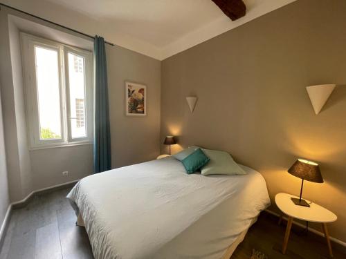 勒拉旺杜的住宿－Les 12 Sables，一间卧室配有一张带两盏灯的床和一扇窗户。