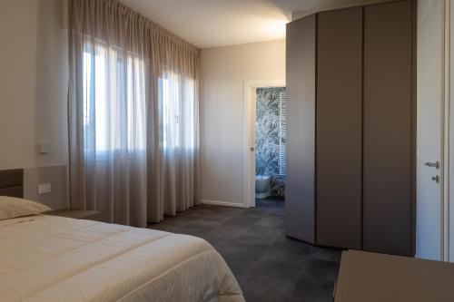 a bedroom with a bed and a door to a bathroom at Suite Dall'Alba al Tramonto in Mogliano Veneto
