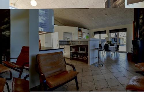 a kitchen and a living room with a chair at Holiday Home Strandparken Otterup Vi in Otterup