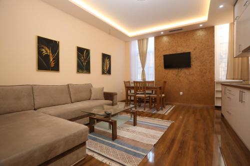 uma sala de estar com um sofá e uma mesa em KARAULA Apartments em Sarajevo