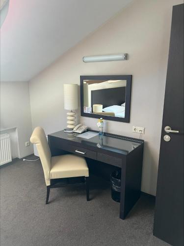 a desk with a chair and a mirror in a room at Optima Collection Troitska in Dnipro