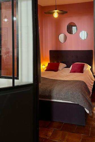 une chambre avec un grand lit avec des oreillers rouges dans l'établissement LE LOFT ESTIENNE D'ORVES, à Marseille