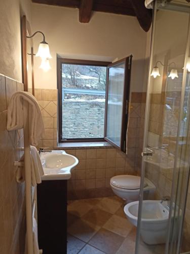 a bathroom with a sink and a toilet and a window at Orchidea Selvatica B&B in Levice