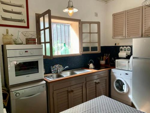 une cuisine avec un évier et une machine à laver dans l'établissement Coeur de Collioure - Parking - Rez de jardin, à Collioure