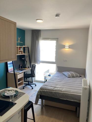 une chambre avec un lit et un bureau avec un ordinateur dans l'établissement KLEY REIMS, à Reims