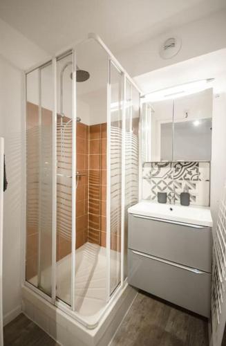 une douche en verre dans une salle de bain avec un lavabo dans l'établissement Chez Anaïs - Charmant studio climatisé proche des plages, à La Grande Motte