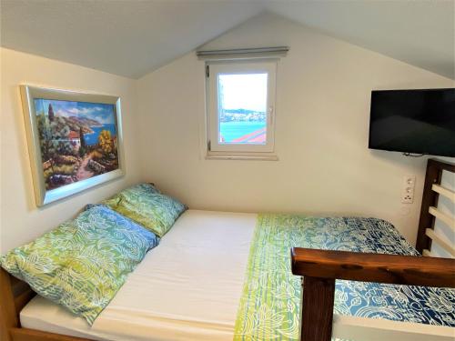 a small bedroom with a bed and a flat screen tv at HAPPY DAYS in Trogir