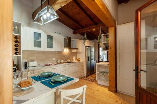 uma cozinha com armários brancos e uma mesa com pratos em Casa Vacanze Margherita em Terra Mala