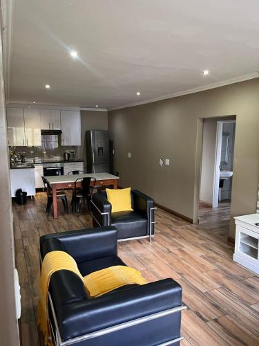 a living room with two couches and a kitchen at Angel Guest House in Johannesburg
