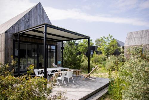 Casa con terraza de madera con mesa y sillas en Sauvage en Quiberon