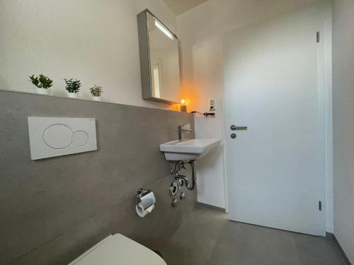 a bathroom with a sink and a toilet and a mirror at H95 Studios in Basel City with Basel Card in Basel