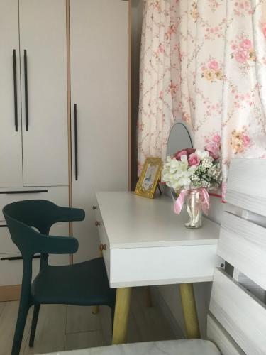 a desk with a chair and a vase of flowers at Macanese Elegant Retreat with Fantastic View of HK Zhuhai Macau Bridge in Macau