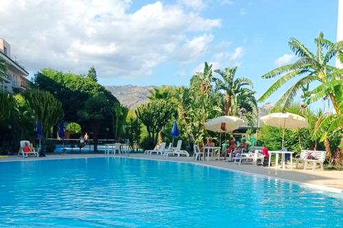 a swimming pool with chairs and umbrellas in a resort at La casa di Giada in Calatabiano