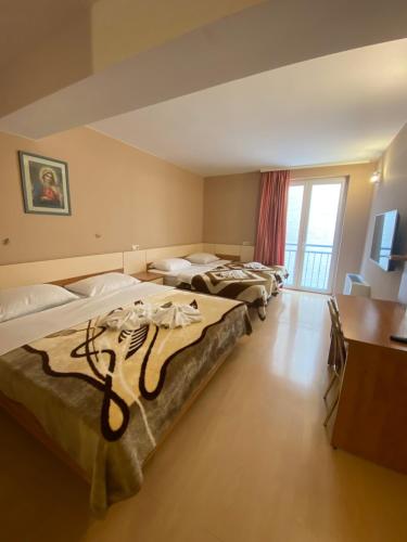 a hotel room with three beds and a desk at Hotel Frankoni in Međugorje