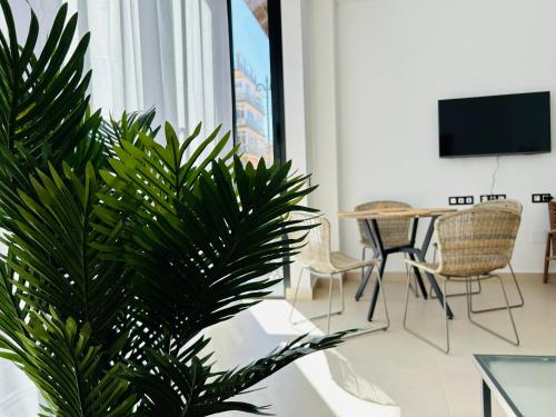 sala de estar con mesa y planta en Victoria Beach Premium, en Málaga