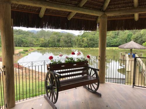 a bench on a porch with a view of a lake at Sítio Paz e Sossego in Têsto Salto
