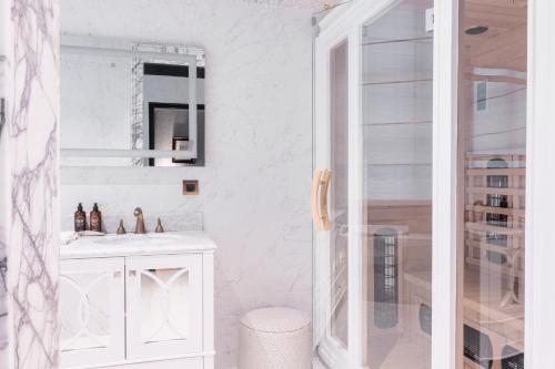 a white bathroom with a sink and a mirror at Juliana Hotel & Spa - Brussels Centre in Brussels