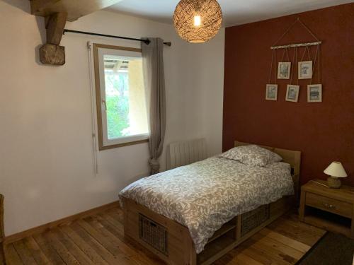 a bedroom with a bed and a window at Gîte 3 étoiles Le Clos des Tilleuls in La Vendelée