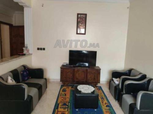 sala de estar con sofás y TV de pantalla plana. en شقتي المفروشة ب سيدي قاسم en Sidi Qacem