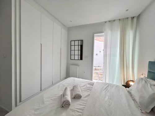 a child laying on a white bed with towels on it at Green Cocoon in Sidi Bou Saïd