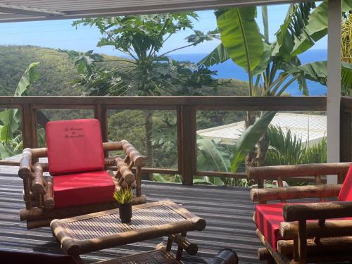 a deck with chairs and a table and a view of the ocean at Le Domaine du Rocher Noir in Pointe-Noire