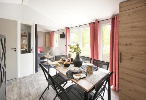a dining room with a long wooden table and chairs at CAMPING PLEIN SOLEIL in Lourdes