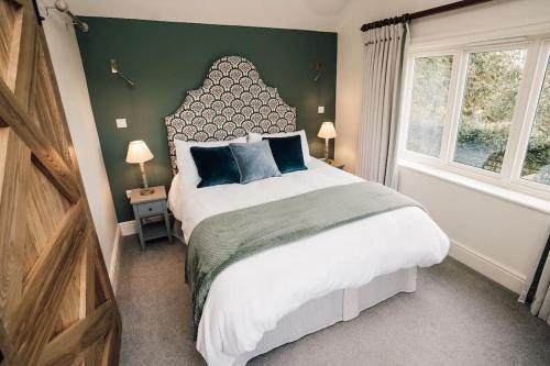 Un dormitorio con una cama grande y una pared verde en Luxury Farm Cottage with Hot Tub, en Northallerton