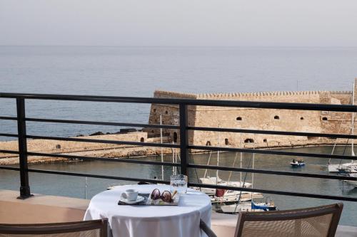 un restaurante con mesa y vistas al océano en Lato Boutique Hotel, en Heraclión