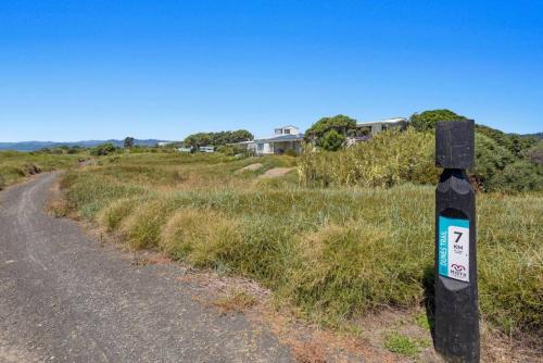 a street sign on the side of a road at Beach Bach on the Dune Trails in Tirohanga
