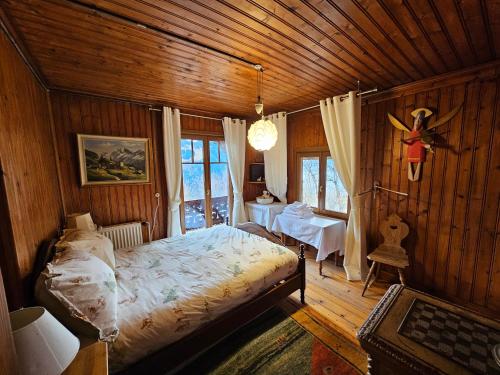 um quarto com uma cama num quarto de madeira em Magnifique Chalet Valérie 5 chambres à coucher & vue unique em Gryon