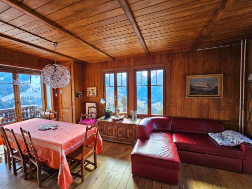 a living room with a table and a couch at Magnifique Chalet Valérie 5 chambres à coucher & vue unique in Gryon