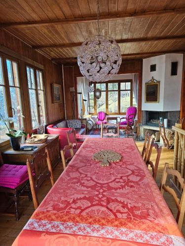 a dining room with a table and chairs and a chandelier at Magnifique Chalet Valérie 5 chambres à coucher & vue unique in Gryon
