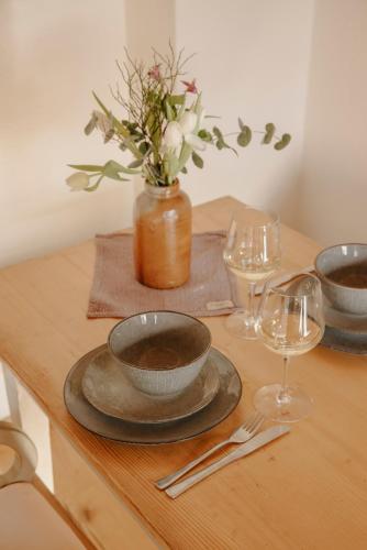 a table with two bowls and a vase with flowers at Staudingerhof in Staudach-Egerndach
