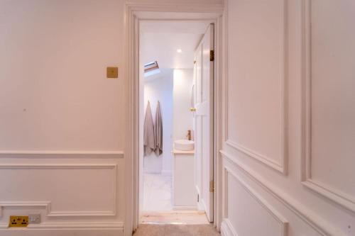 a hallway with a door leading to a bathroom at Elegant 3 bedroom home in the centre of Cheltenham in Cheltenham