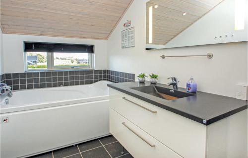 a bathroom with a sink and a bath tub at Holiday Home Flovt Havevej Ix in Flovt