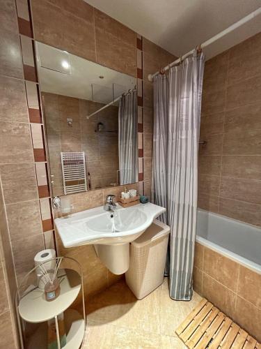 a bathroom with a sink and a tub and a mirror at The Nature View Suite, part of Terra Complex & Spa in Bansko