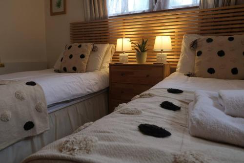 two beds sitting next to each other in a bedroom at Cosy 2-bedroom cottage in the Lake District in Bowness-on-Windermere