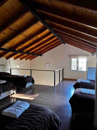 a room with two beds and a wooden ceiling at Departamento con parrilla in San Carlos de Bariloche