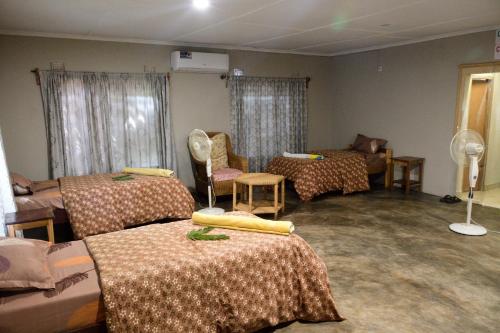 Mfuwe的住宿－KUDU SAFARI LODGE (Mfuwe, Zambia)，一间设有三张床的房间和一间设有房间的房间