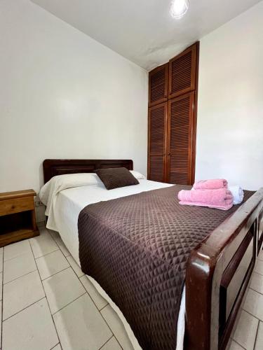 um quarto com uma cama com toalhas cor-de-rosa em Selva Guazú Apart em Puerto Iguazú